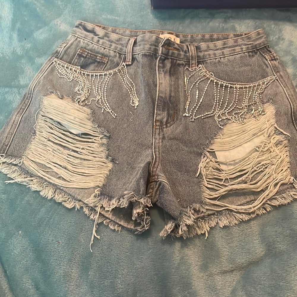 Bling Tassels hanging down on front pockets and distress on front of the shorts